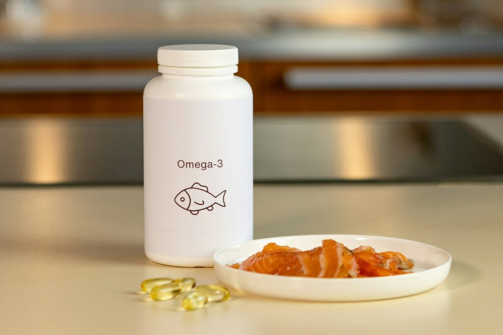 1 flacon de complément alimentaire d'oméga 3 et une assiette de saumon